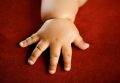 Children's hand isolated on red background